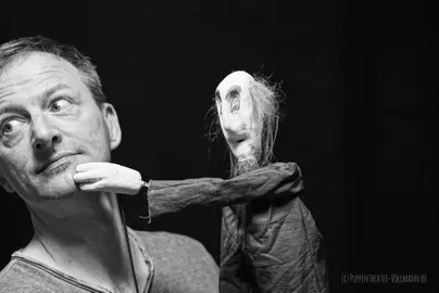 Ein Mann mit einem Schaumgummikopf auf der Hand