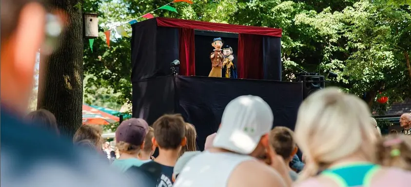 Familien vor eine Puppenbühne im Freien