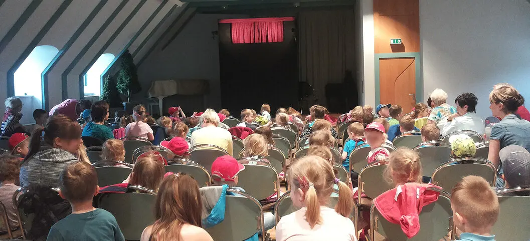 Familien vor eine Puppenbühne in einem Kulturhaus