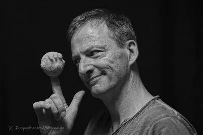 Ein Mann mit einem Schaumgummikopf auf der Hand